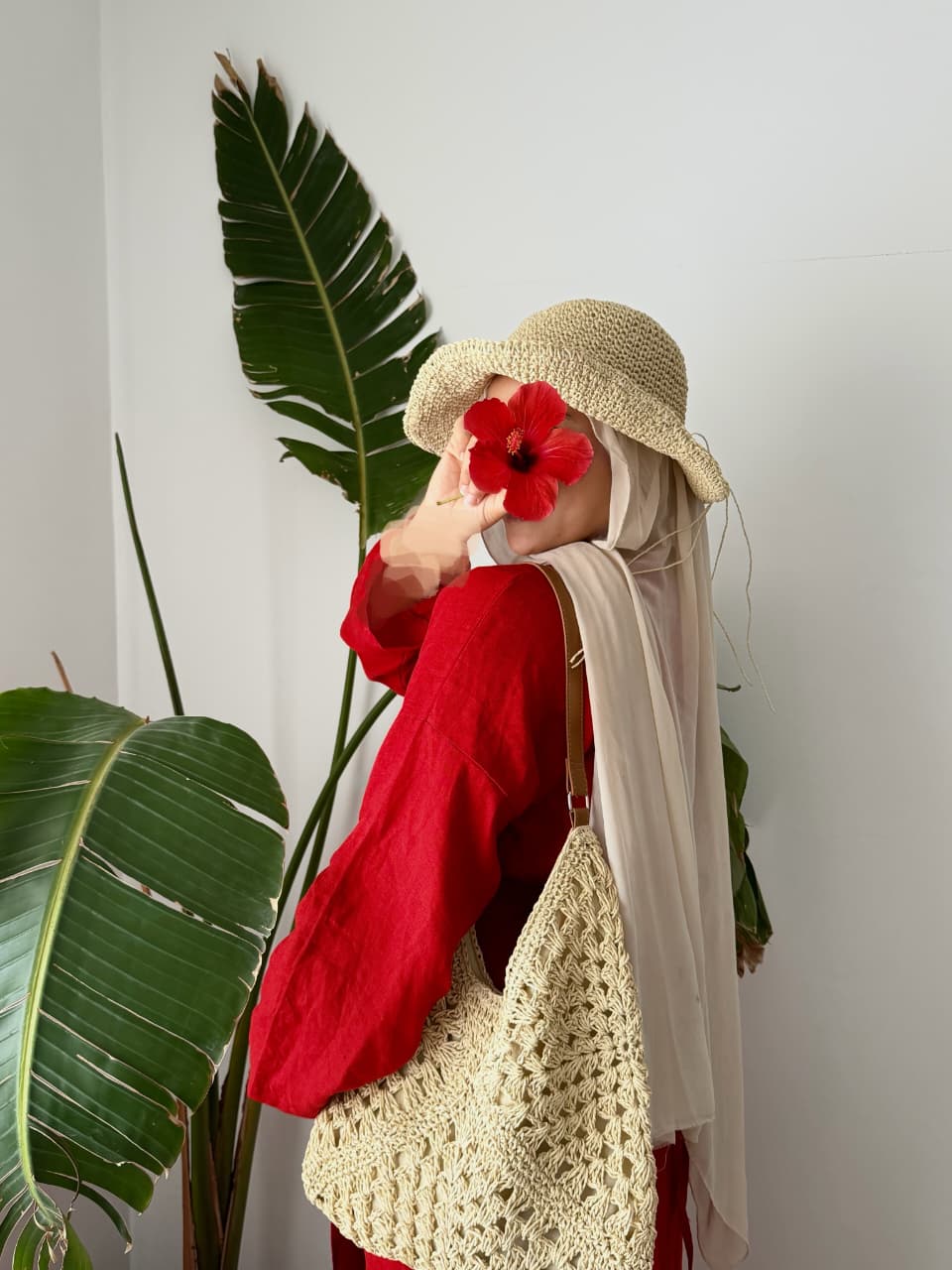 Pull rouge de profil, chapeau de paille et sac en crochet — Amenti Collection